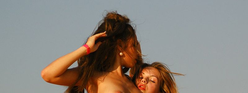 Twee vrouwen, naakt dansen op het strand