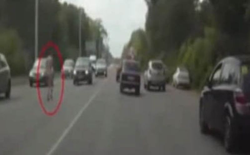 Naakte Russische vrouw rent door verkeer