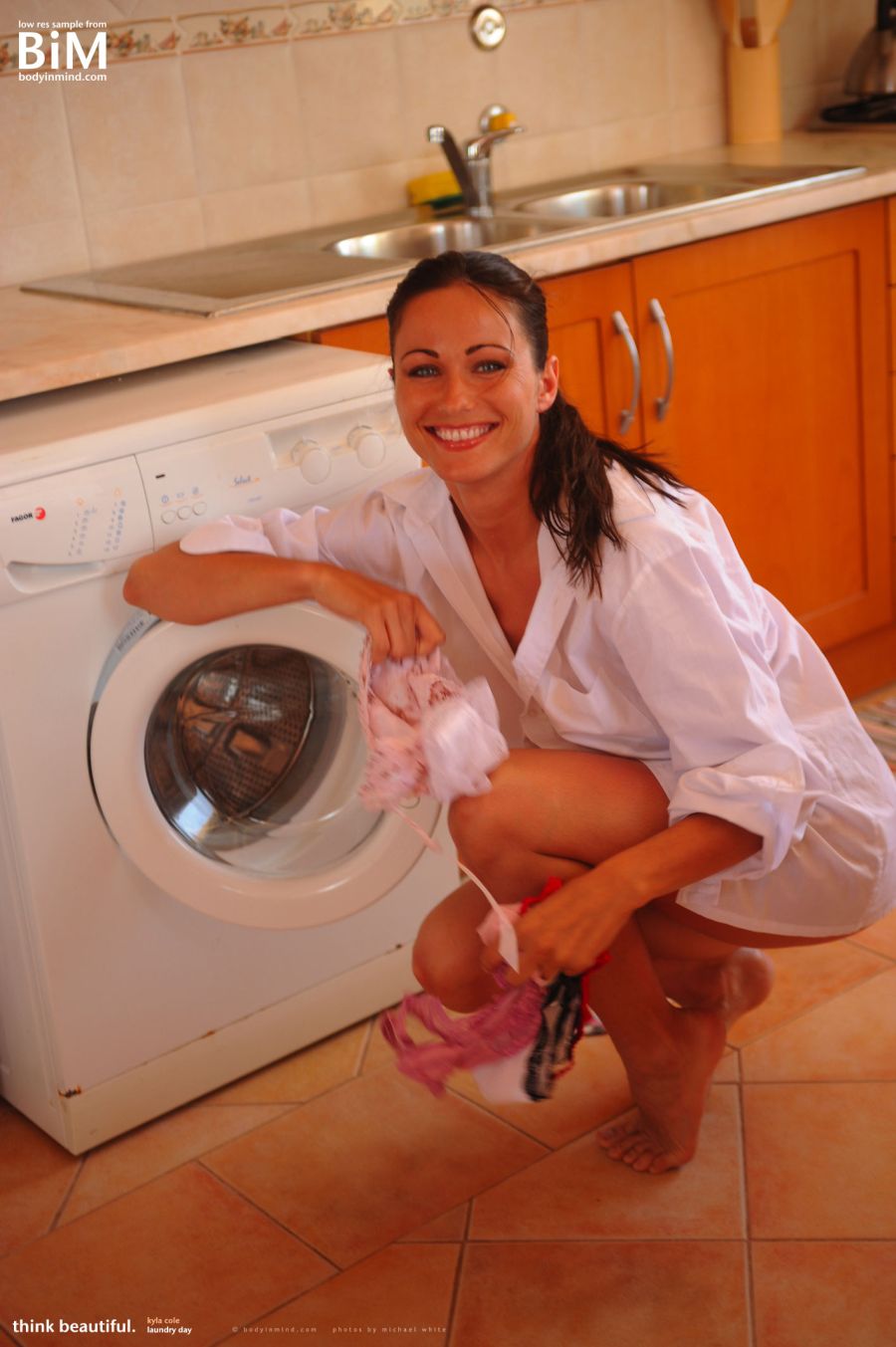 Kyla is doing the laundry, naked