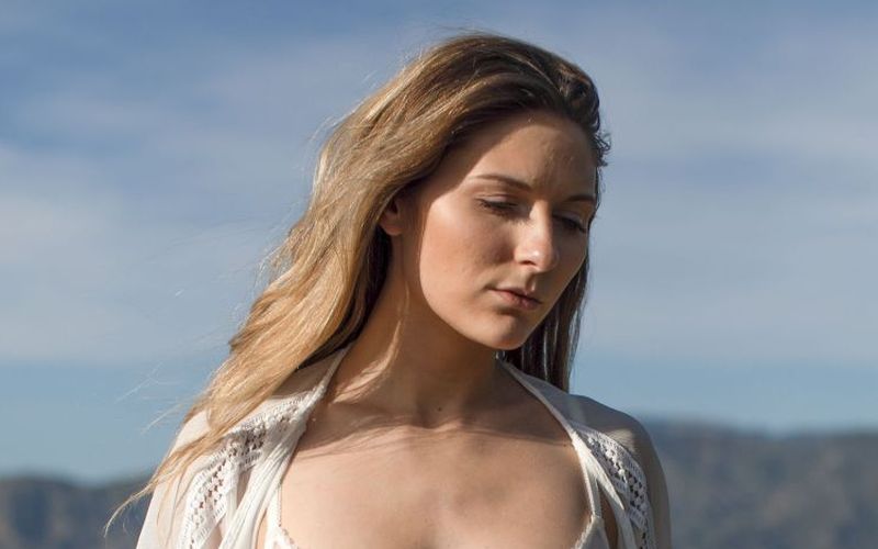 Knappe brunette met grote borsten gaat bloot in de natuur