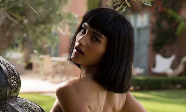 Mooie exotische vrouw, grote borsten, gaat bloot in de tuin