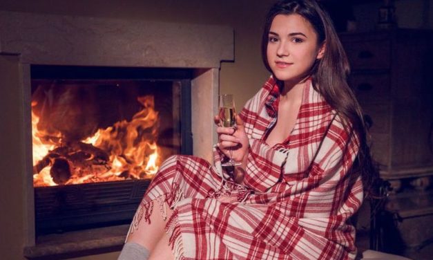 Knappe brunette, grote borsten, gaat naakt voor de openhaard