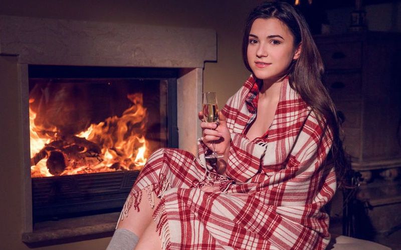 Knappe brunette, grote borsten, gaat naakt voor de openhaard