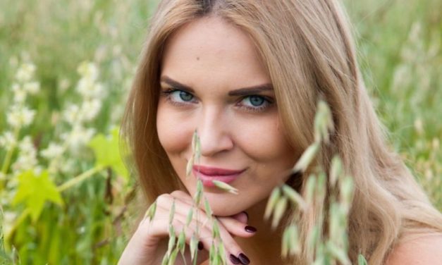 Knappe vrouw gaat helemaal bloot in het hoge gras