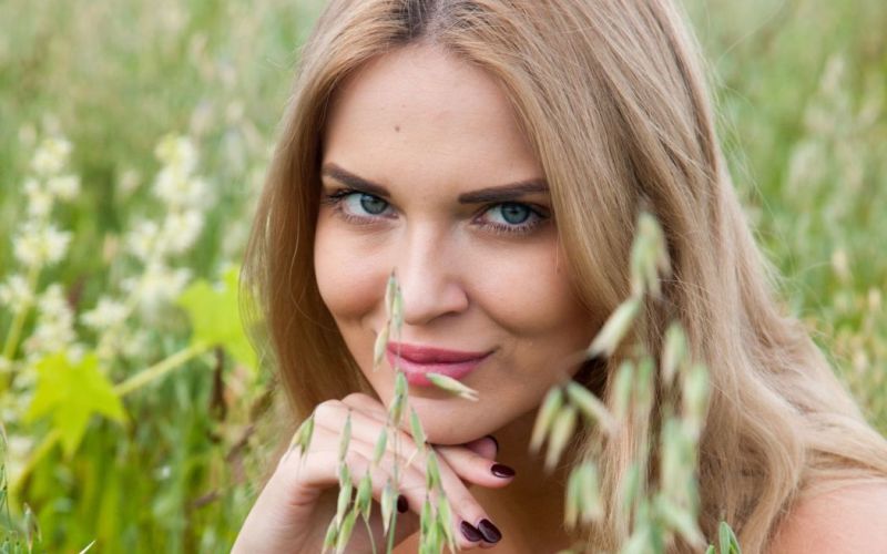 Knappe vrouw gaat helemaal bloot in het hoge gras