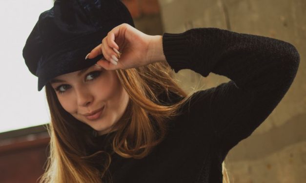 Knappe blonde tiener met een trendy muts op gaat naakt