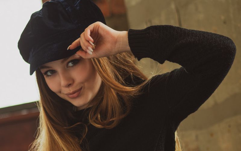 Knappe blonde tiener met een trendy muts op gaat naakt