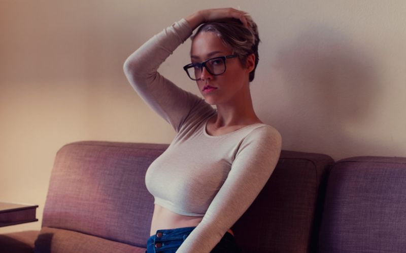 Sabrina Bunny, kort haar en grote borsten, topless op de bank