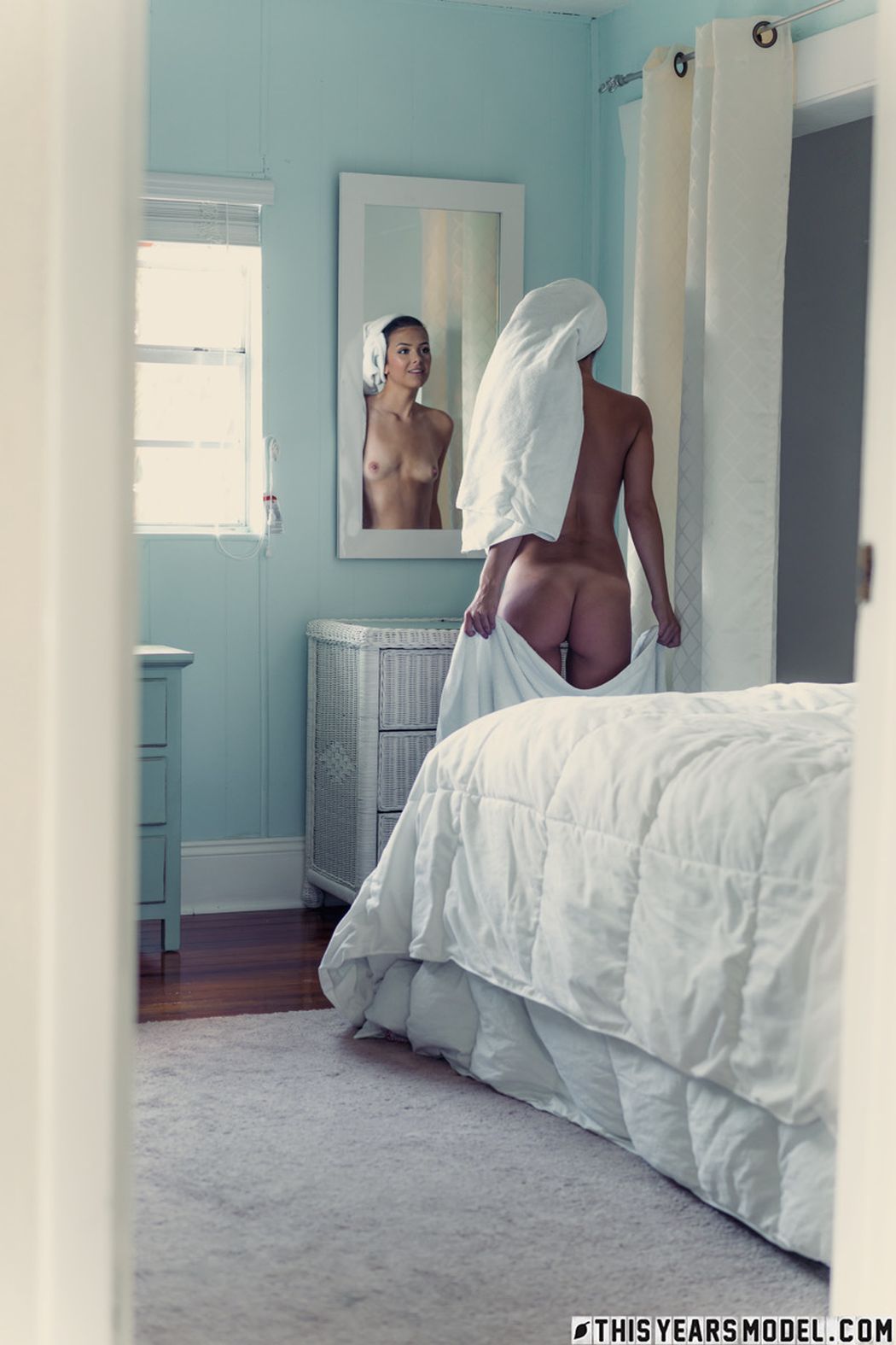 Ze laat de handdoek van zich af glijden