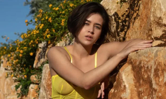 Een naakte hete vrouw leunt tegen stenen